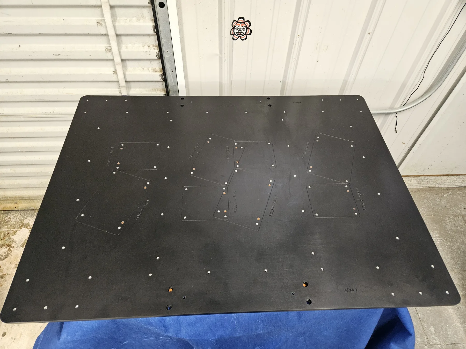 Large black anodized plate with a machined hole pattern finished at AnoPRO