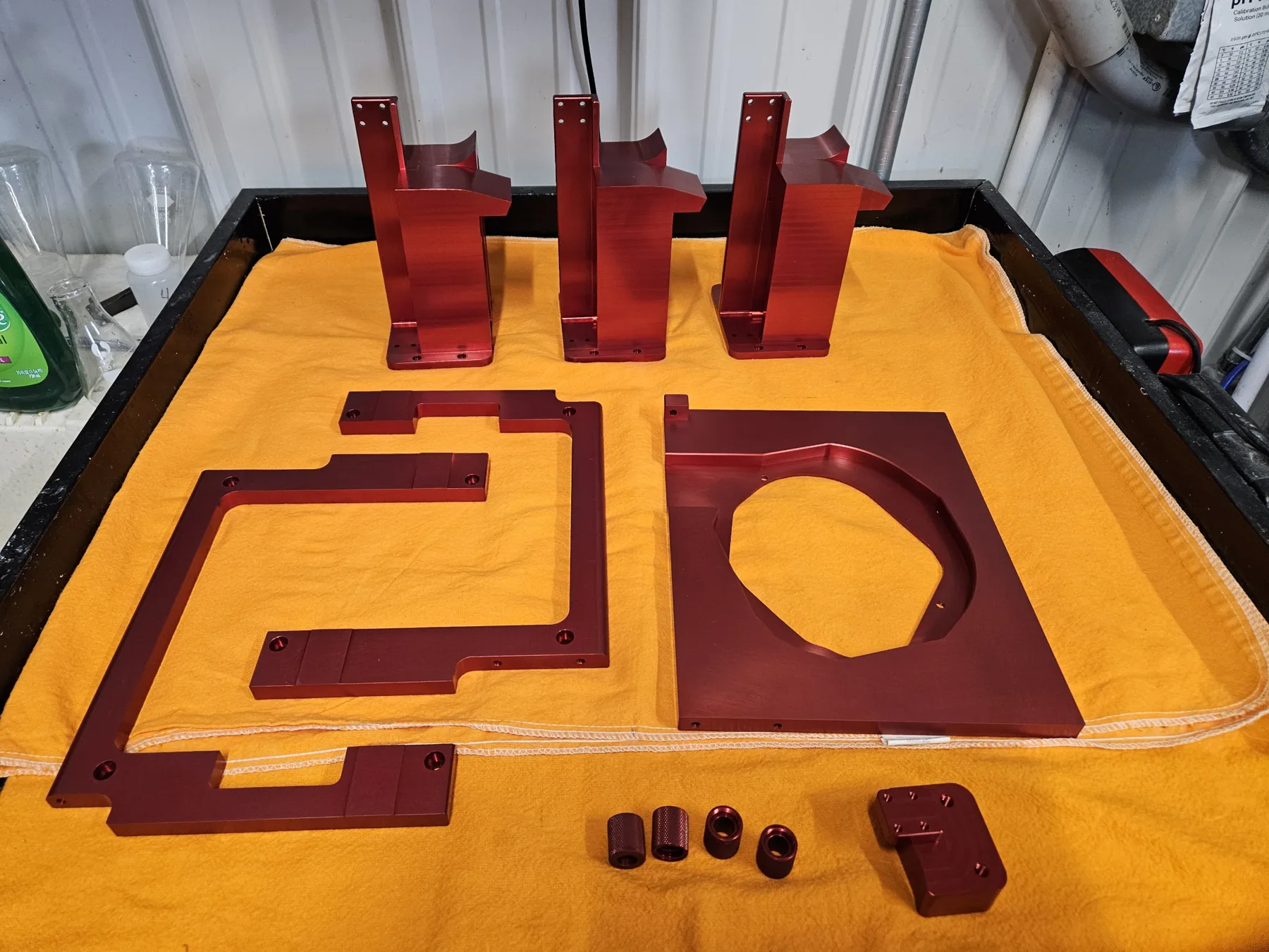 Red anodized brackets, plates, and fittings finished at AnoPRO